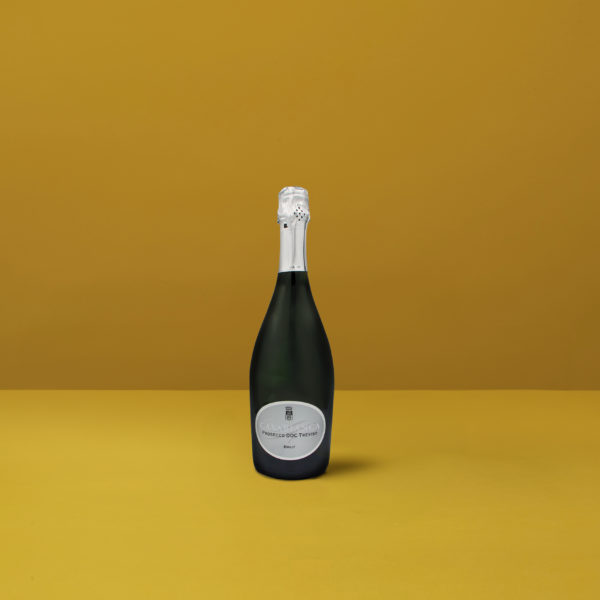 Una luminosa bottiglia di Prosecco Brut Treviso Casabianca DOCG su sfondo giallo, che incarna la freschezza e l&#039;eleganza dello spumante italiano.