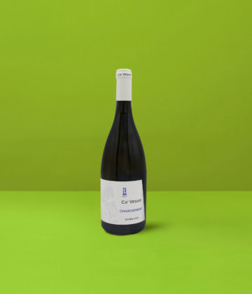 Eine strahlende Flasche Ca&#039; Vegar Chardonnay Garda DOC auf grünem Hintergrund, die das perfekte Gleichgewicht zwischen Frische und Komplexität repräsentiert.