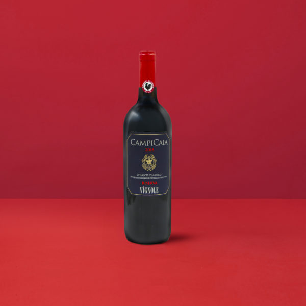 Élégante bouteille de Chianti Classico Riserva Vignole DOCG sur un fond rouge vibrant