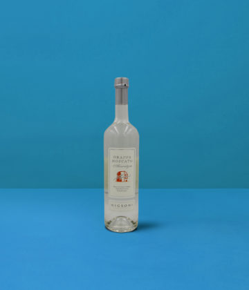 Flasche Grappa Moscato Negroni (70cl) auf blauem Hintergrund, ein Spiegelbild der handwerklichen Destillation und der italienischen Qualität.