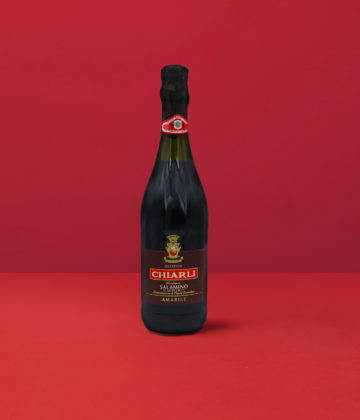 Flasche Lambrusco Classico Salamino - Chiarli DOC auf einem eleganten roten Hintergrund.