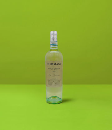Un'elegante bottiglia di Pinot Grigio Le Rosse Tommasi IGT con sfondo verde, che cattura la luminosità e la finezza del vino bianco italiano.