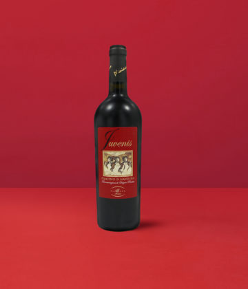 Bottiglia di Primitivo di Manduria Juvenis DOP che esprime il colore rosso rubino intenso e la vitalità del vino di Manduria.