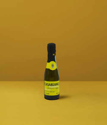 Eine kleine Flasche Prosecchino Extra Dry Casabianca DOCG mit seiner hellgelben Farbe und den feinen Bläschen, perfekt für einen festlichen Toast.